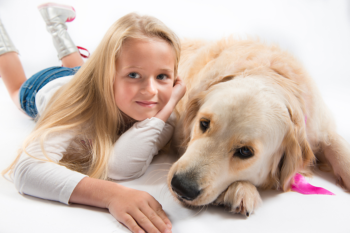 a girl and golden retriver studio photo