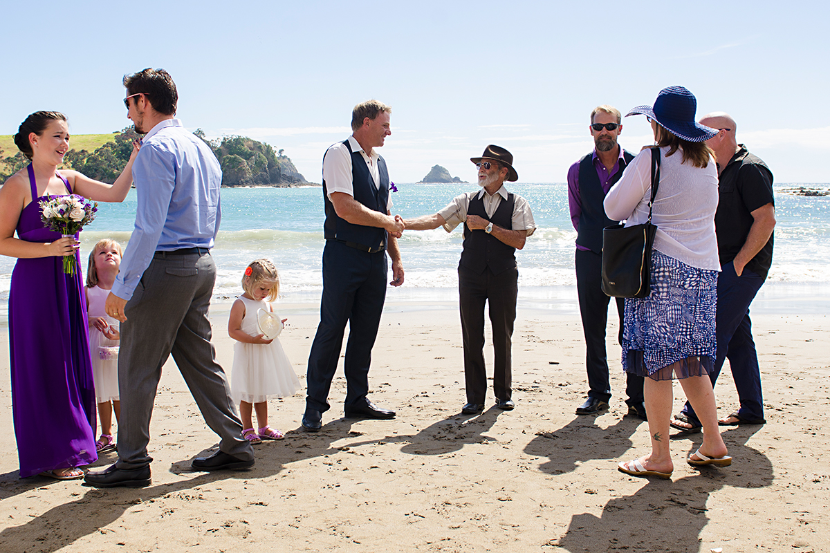 guests congratulating groom oafter wedding ceremony NZ beach northland